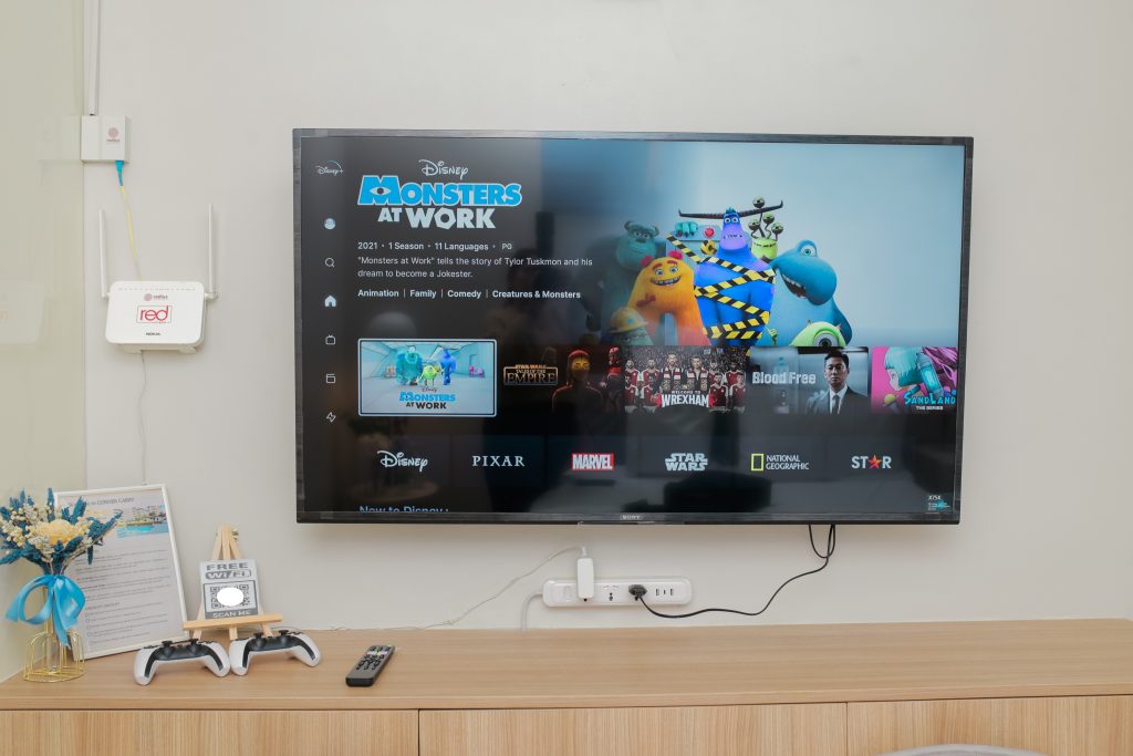 A 55-inch smart TV on top of a long table that can be used as a workspace or dining area.